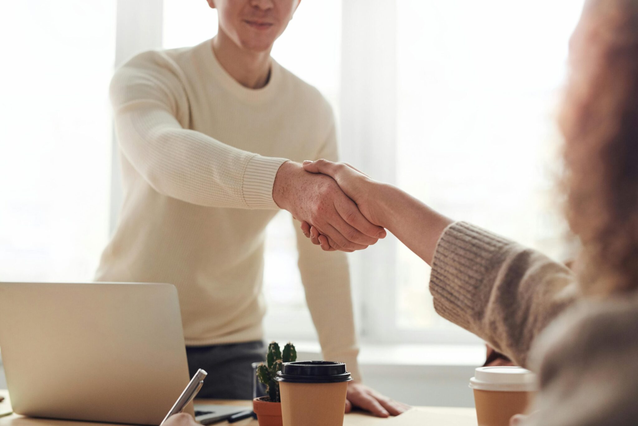 New starter assessments - A hand shake over a desk